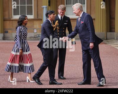 Sir Clive Alderton, segretario privato principale del re e della regina (a destra) con il comandante William Thornton, Royal Navy, Equerry to the King (2° a destra) salutano Rishi Sunak e sua moglie Akshata Murty, mentre arriva a Buckingham Palace per un'udienza con re Carlo III per dimettersi formalmente come primo ministro dopo la schiacciante vittoria elettorale generale per il Partito Laburista. Data foto: Venerdì 5 luglio 2024. Foto Stock