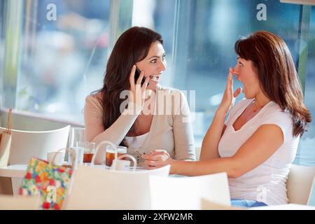 Parlare per telefono. Le sorelle di 35 e 40 anni prendono il caffè in terrazza. Donostia. San Sebastian. Gipuzkoa. Paesi Baschi - Spagna. Foto Stock