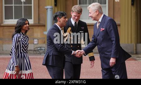 Sir Clive Alderton, segretario privato principale del re e della regina (a destra) con il comandante William Thornton, Royal Navy, Equerry to the King (2° a destra) salutano Rishi Sunak e sua moglie Akshata Murty, mentre arriva a Buckingham Palace per un'udienza con re Carlo III per dimettersi formalmente come primo ministro dopo la schiacciante vittoria elettorale generale per il Partito Laburista. Data foto: Venerdì 5 luglio 2024. Foto Stock