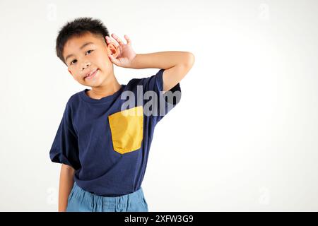 Ritratto bambino asiatico sorridente udito ascoltare il suono di gossip con attenzione con la mano sopra Foto Stock