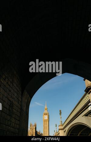 "Big Ben" Elizabeth Tower of the Palace of Westminster vista da un arco attraverso il Riover Tamigi sotto Westminster Bridge, Londra, Regno Unito Foto Stock