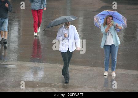 San Pietroburgo, Russia. 4 luglio 2024. Le persone si riparano sotto gli ombrelli mentre camminano lungo la strada durante le forti piogge nel centro di San Pietroburgo. Credito: SOPA Images Limited/Alamy Live News Foto Stock