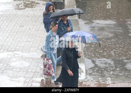 San Pietroburgo, Russia. 4 luglio 2024. Le persone si riparano sotto gli ombrelli mentre camminano lungo la strada durante le forti piogge nel centro di San Pietroburgo. Credito: SOPA Images Limited/Alamy Live News Foto Stock