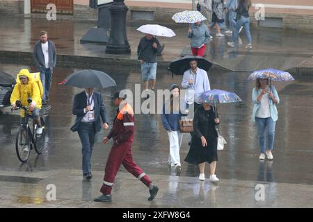 San Pietroburgo, Russia. 4 luglio 2024. Le persone si riparano sotto gli ombrelli mentre camminano lungo la strada durante le forti piogge nel centro di San Pietroburgo. Credito: SOPA Images Limited/Alamy Live News Foto Stock