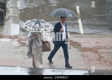 San Pietroburgo, Russia. 4 luglio 2024. Le persone si riparano sotto gli ombrelli mentre camminano lungo la strada durante le forti piogge nel centro di San Pietroburgo. Credito: SOPA Images Limited/Alamy Live News Foto Stock