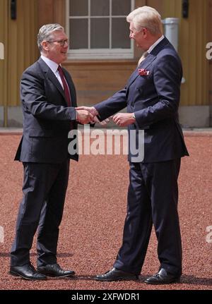 Sir Clive Alderton, primo segretario privato del re e della regina (a destra) saluta Sir Keir Starmer mentre arriva a Buckingham Palace a Londra per un'udienza con re Carlo III, dove sarà invitato a diventare primo ministro e formare un nuovo governo, dopo la schiacciante vittoria elettorale generale per il Partito Laburista. Data foto: Venerdì 5 luglio 2024. Foto Stock