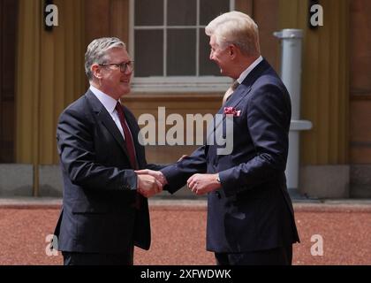 Sir Clive Alderton, primo segretario privato del re e della regina (a destra) saluta Sir Keir Starmer mentre arriva a Buckingham Palace a Londra per un'udienza con re Carlo III, dove sarà invitato a diventare primo ministro e formare un nuovo governo, dopo la schiacciante vittoria elettorale generale per il Partito Laburista. Data foto: Venerdì 5 luglio 2024. Foto Stock