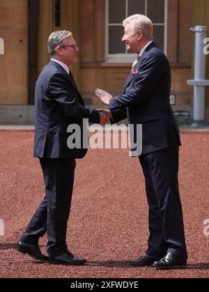 Sir Clive Alderton, primo segretario privato del re e della regina (a destra) saluta Sir Keir Starmer mentre arriva a Buckingham Palace a Londra per un'udienza con re Carlo III, dove sarà invitato a diventare primo ministro e formare un nuovo governo, dopo la schiacciante vittoria elettorale generale per il Partito Laburista. Data foto: Venerdì 5 luglio 2024. Foto Stock