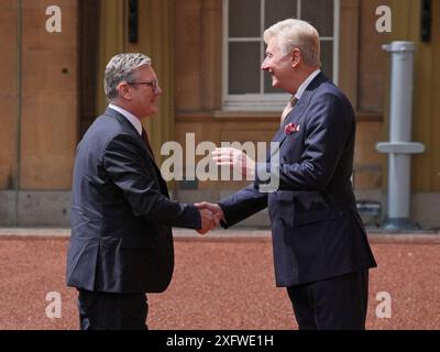 Sir Clive Alderton, primo segretario privato del re e della regina (a destra) saluta Sir Keir Starmer mentre arriva a Buckingham Palace a Londra per un'udienza con re Carlo III, dove sarà invitato a diventare primo ministro e formare un nuovo governo, dopo la schiacciante vittoria elettorale generale per il Partito Laburista. Data foto: Venerdì 5 luglio 2024. Foto Stock