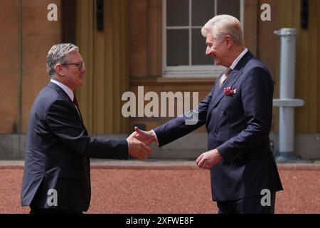 Sir Clive Alderton, primo segretario privato del re e della regina (a destra) saluta Sir Keir Starmer mentre arriva a Buckingham Palace a Londra per un'udienza con re Carlo III, dove sarà invitato a diventare primo ministro e formare un nuovo governo, dopo la schiacciante vittoria elettorale generale per il Partito Laburista. Data foto: Venerdì 5 luglio 2024. Foto Stock