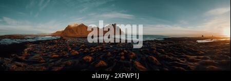 Vista panoramica delle montagne rocciose vicino al mare sul cielo al tramonto Foto Stock