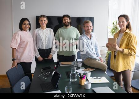 Ritratto di uomini d'affari sorridenti e donne d'affari sul tavolo in ufficio Foto Stock