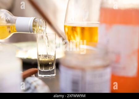 Birra versata nel bicchiere da shot Foto Stock