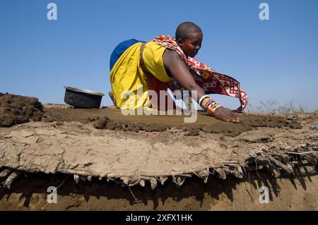 Donna Maasai che costruisce una capanna di fango villaggio Maasai, Kenya. Settembre 2006. Foto Stock