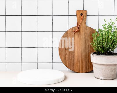 Elegante sfondo bianco da cucina con podio rotondo bianco in marmo per pubblicizzare prodotti ecologici o sani, alimenti, oggetti per la cucina. Tagliere e. Foto Stock