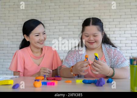 Una madre si prende cura amorevolmente di sua figlia con la sindrome di Down a casa Foto Stock