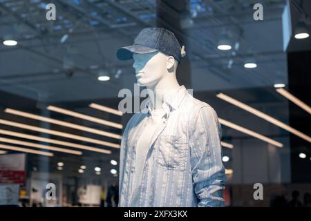 Il manichino è vestito con un cappellino da baseball e una camicia a righe, fermo per la fotografia flash, che rappresenta l'arte e la scultura nel fashion design Foto Stock