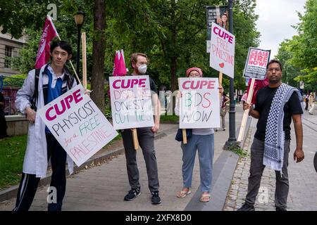 Le persone hanno dei cartelli a sostegno della Palestina durante la manifestazione al King's College Circle nel campus dell'Università di Toronto. Foto Stock