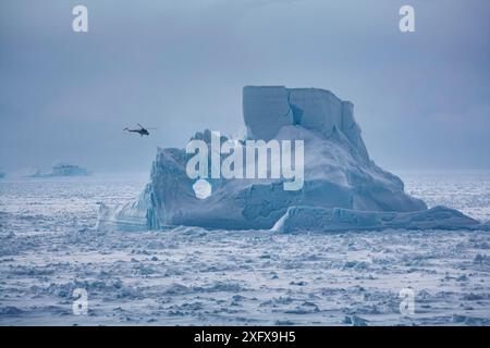 L'elicottero dal rompighiaccio russo Kapitan Khlebnikov vola oltre l'iceberg nel Mare di Weddell vicino alla colonia di pinguini dell'imperatore dell'isola di Snow Hill, Antartide. Foto Stock