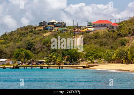 Vista di Mayreau sulla spiaggia, le barche, il molo e le case; baia di Saline: Mayreau, Saint Vincent e Grenadine. (Prima dell'uragano Beryl) Foto Stock