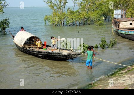 I bambini del villaggio rurale giocano a cricket sulla riva del fiume Sundarbans Island, Bengala Occidentale, India. Foto Stock