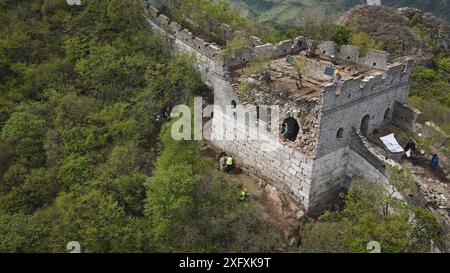 (240705) -- PECHINO, 5 luglio 2024 (Xinhua) -- una foto aerea scattata il 30 aprile 2024 mostra i lavoratori che lavorano in un sito archeologico di una torre di guardia della sezione Jiankou della grande Muraglia a Pechino, capitale della Cina. Quarant’anni fa, a Pechino è stata lanciata una campagna per proteggere la grande Muraglia con l’aiuto dei fondi sociali. Oggi le forze sociali svolgono ancora un ruolo cruciale nella protezione e nel restauro della grande Muraglia. Un progetto di restauro in corso della sezione Jiankou della grande Muraglia adotta un approccio "archeologia e restauro simultaneo", dove i lavori archeologici sono completi Foto Stock