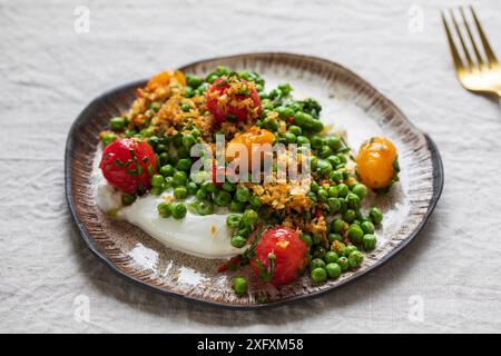 Burrata con piselli verdi grigliati, pomodori sottaceto e pangrattato Foto Stock