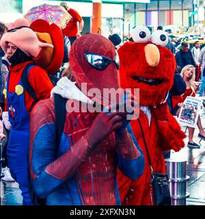 New York, USA - 19 maggio 2024: Una persona vestita da Spider-Man si trova vicino a una persona vestita da Elmo a Times Square, entrambe rivolte verso la macchina fotografica Foto Stock