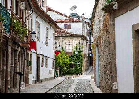 Guimaraes, Portogallo - 19 giugno 2024: Strada storica e stretta nella Guimaraes medievale, la prima capitale del Portogallo Foto Stock