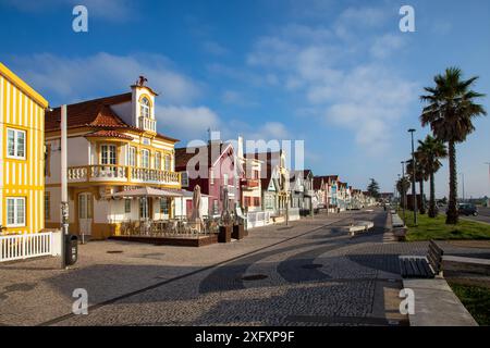 Costa Nova, Portogallo - 21 giugno 2024: Case colorate a righe chiamate Palheiros con strisce rosse, blu e verdi Foto Stock