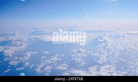 Bellissime nuvole bianche contro il cielo blu viste dall'alto, da una finestra piana. Concetto di viaggio. Foto Stock