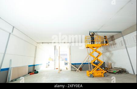 Lavoratore a lavorare per la costruzione di una parete di cartongesso. Foto Stock