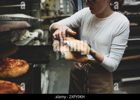 La produzione giornaliera di pane cotto con forno a legna con il metodo tradizionale. Foto Stock