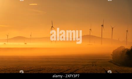 Turbine eoliche del parco eolico di Bründersen-Istha nella nebbia mattutina, campi in primo piano. Distretto di Waldeck-Frankenberg, Assia, Germania. Foto Stock