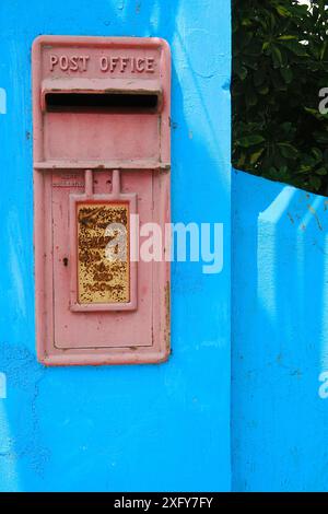 La vecchia e colorata cartolina di George vi, incastonata in un muro a Tobago, Caraibi Foto Stock