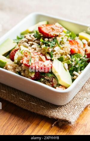Ciotola con insalata di fragole di quinoa con spinaci e avocado. Foto Stock