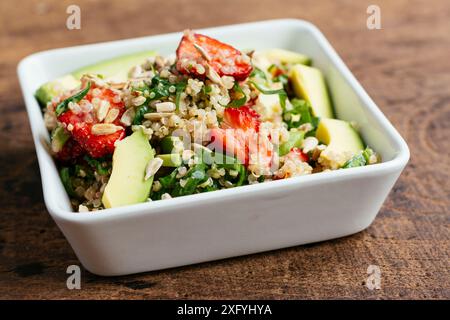 Ciotola con insalata di fragole di quinoa con spinaci e avocado. Foto Stock