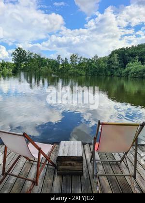 Due sdraio su un molo sulla riva vi invitano a rilassarvi, in sottofondo nuvole pesanti nel cielo in una giornata estiva in agosto, cambiamenti climatici, Renania settentrionale-Vestfalia, Germania Foto Stock