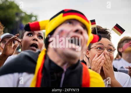 Berlino, Germania. 5 luglio 2024. Calcio: Campionato europeo, Germania - Spagna, finale, quarti di finale, pubblico di Berlino. I tifosi tedeschi reagiscono nella zona dei tifosi alla porta di Brandeburgo. Crediti: Christoph Soeder/dpa/Alamy Live News Foto Stock