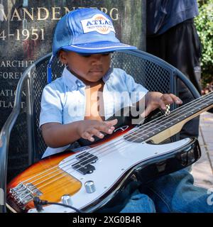 Grand Rapids, Michigan - Un ragazzo si diverte con una chitarra elettrica durante il concorso ArtPrize. La mostra d'arte annuale e l'evento culturale sono caratterizzati da Foto Stock