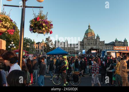 Victoria, CANADA - 1 luglio 2024 : Una grande folla si riunisce nel centro di Victoria. Persone, bancarelle alimentari e il Parlamento possono essere visti in un'immagine. Foto Stock