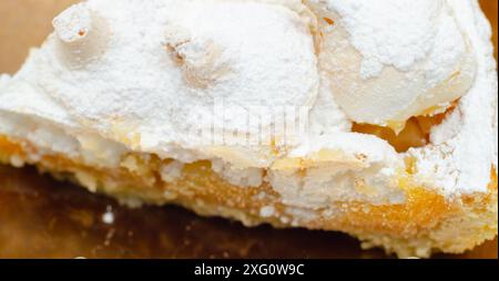 Una fetta di torta con molto zucchero a velo sopra. La torta viene tagliata a metà e si siede su un piatto Foto Stock