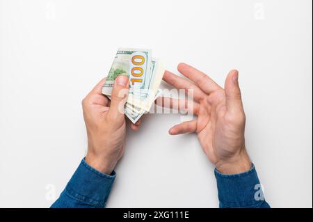 Un uomo d'affari che tiene in mano una pila di banconote in euro, punta il dito contro denaro, reddito, successo Foto Stock