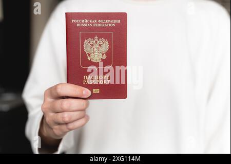 Passaporto della Federazione russa. Mano umana con passaporto russo primo piano, messa a fuoco selettiva, sfocatura. Passaporto di viaggio Foto Stock