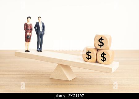 Concetto di equilibrio tra vita e lavoro o denaro. Figurine di coppia e simbolo del dollaro sui blocchi di legno sulla seesaw di legno Foto Stock