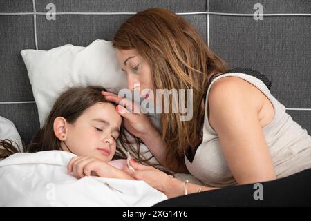 Madre che si prende cura di sua figlia ammalata.Foto di alta qualità Foto Stock