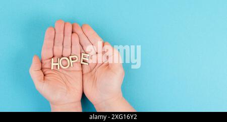 Tenendo la parola speranza nel palmo delle mani, fidarsi e credere concetto, avendo fede nel futuro, fiducioso mentalità positiva Foto Stock