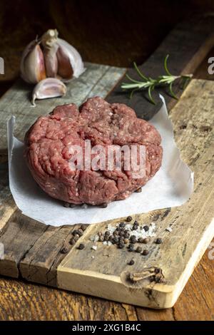 Carne macinata cruda su legno scuro Foto Stock