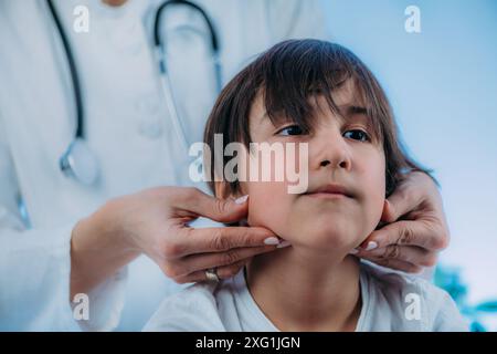 Endocrinologo pediatrico che esamina un bambino. Foto Stock