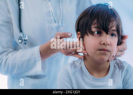 Endocrinologo pediatrico che esamina i linfonodi di un bambino. Foto Stock